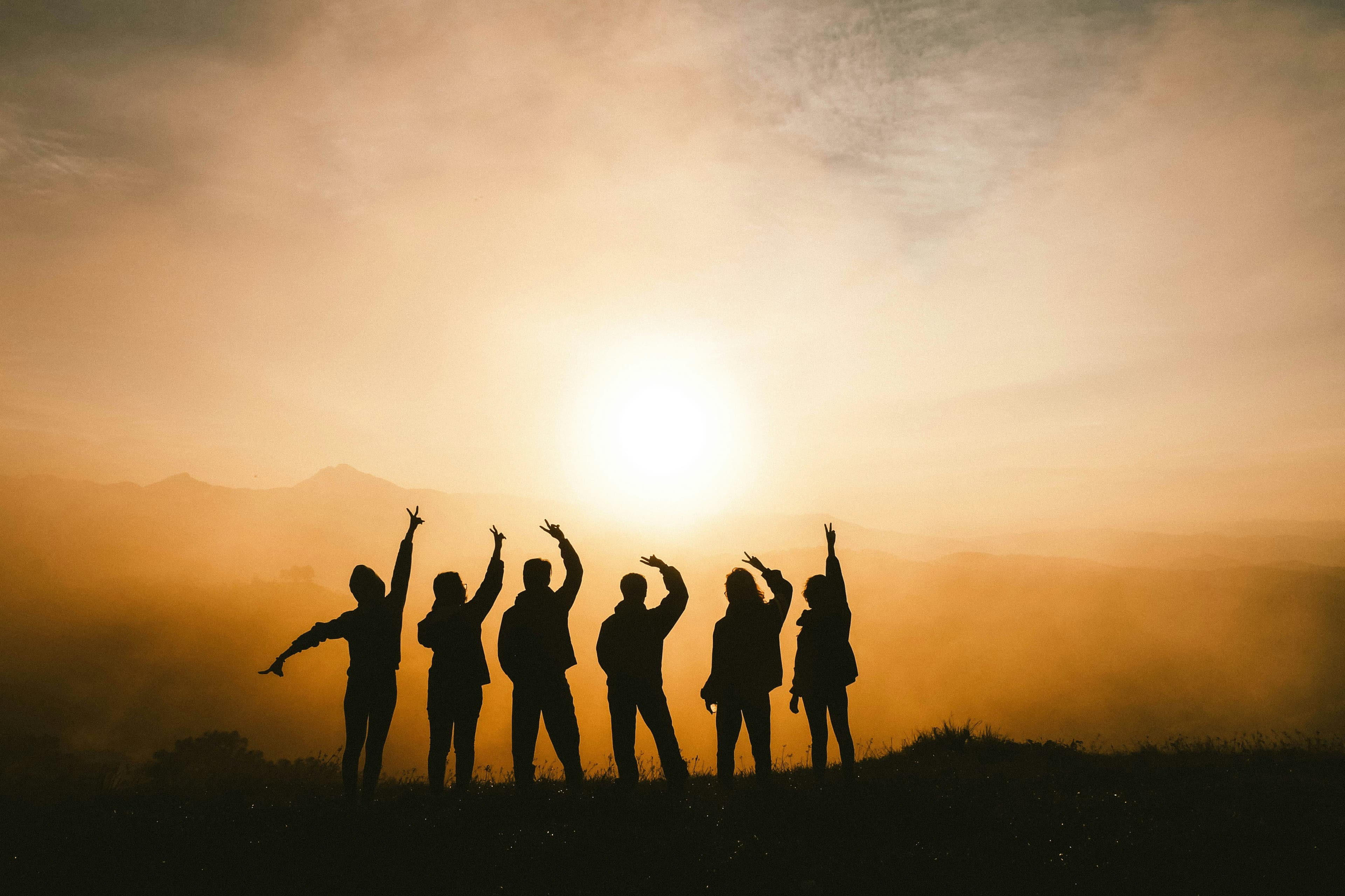 People worshipping at sunset